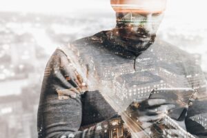 Double exposure of city and man using smart tablet