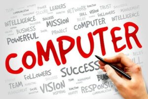 Hand writing the word "COMPUTER" in red among a variety of related words such as "intelligence," "network," "IT Service Provider," and "success" on a whiteboard.