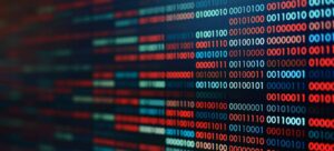 A close-up of a digital screen displaying alternating patterns of binary code, with sequences of red, blue, and white zeros and ones.